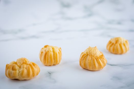 Delicious eclair vanilla cream, choux dough filled with a cream, homemade bakery on white marble background for snack eating concept