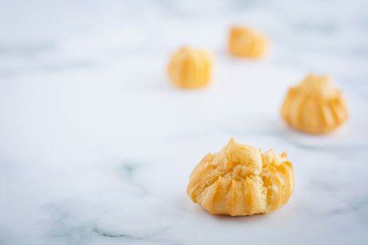 Delicious eclair vanilla cream, choux dough filled with a cream, homemade bakery on white marble background for snack eating concept