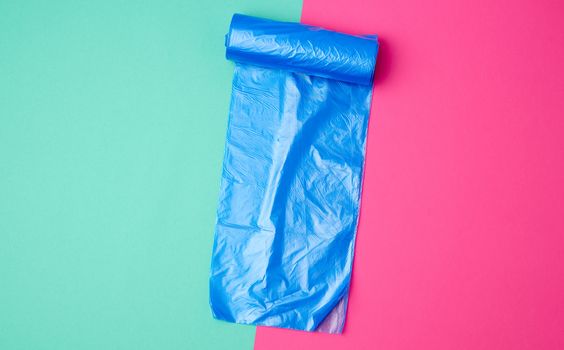 detailed blue plastic bag for collecting garbage and bin on a colored background, top view