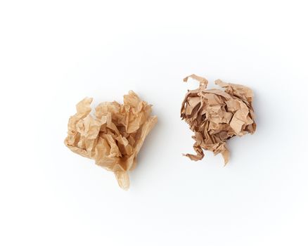 two crumpled sheets of brown paper on a white background, close up, top view