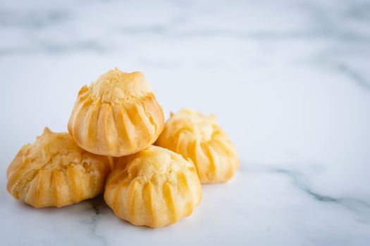 Delicious eclair vanilla cream, choux dough filled with a cream, homemade bakery on white marble background for snack eating concept