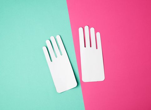 two empty paper white patterns for gloves on a colored background