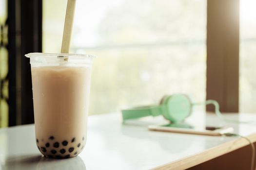 Bubble tea in plastic cup on white table with blurred background for drinks and beverage at home concept