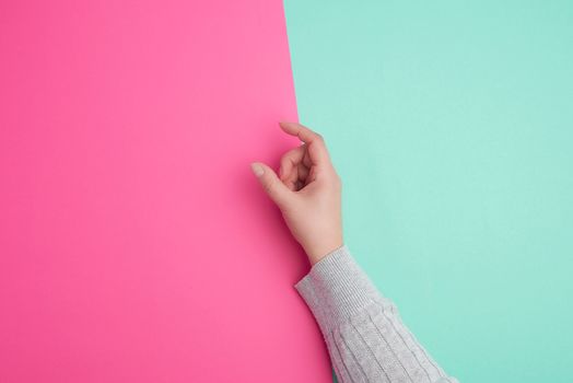 female hand on a green background, fingers in the gesture of holding the subject, copy space