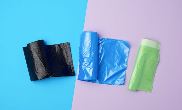 three rolled up rolls with plastic garbage bags on a blue background