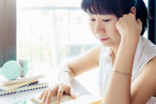 Asian woman thinking about work with blurred background for staying and working at home concept