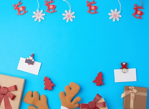  closed square gift boxes with bows on a blue background, top view, place for text