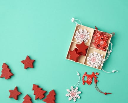 wooden carved Christmas decorations for the holiday tree on a green background, top view