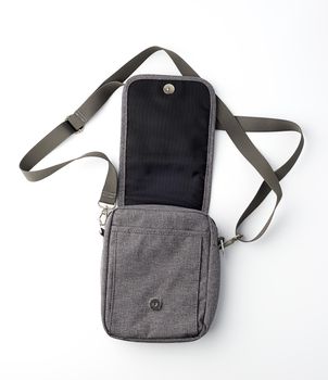 open gray textile men's bag with a long strap on a white background, top view