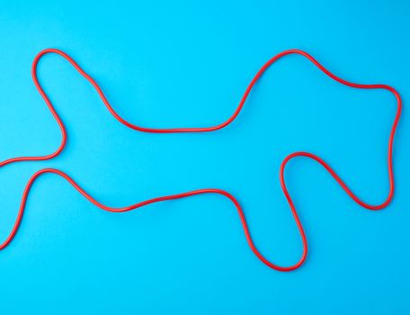 fragment of a red jump rope for sports on a blue background, two lines