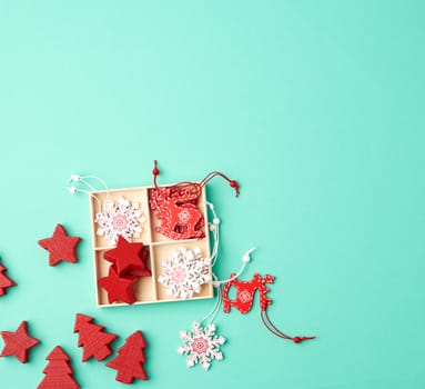 wooden carved Christmas decorations for the holiday tree on a green background, top view