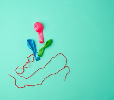 deflated rubber balls and red rope on a green background, copy space