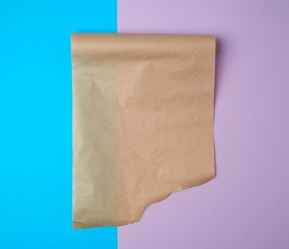 unwrapped a roll of brown parchment paper on a colored background, place for text