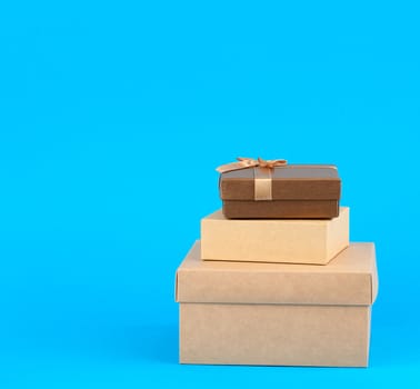 stack of closed various cardboard boxes on a blue background, close up
