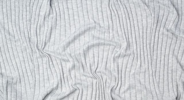 fragment of gray knitted fabric, full frame, fabric for sweaters, wavy surface