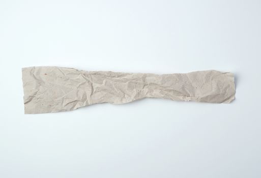 crumpled torn piece of gray paper on a white background, close up