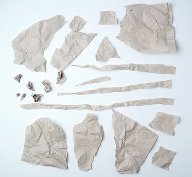 a set of various pieces of torn gray crumpled paper on a white background, close up