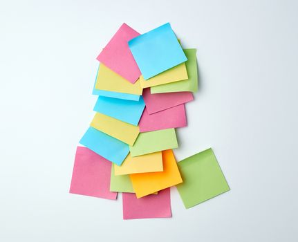 pile of empty multicolored paper square stickers on white background, close up