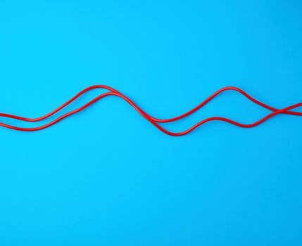 fragment of a red jump rope for sports on a blue background, two lines