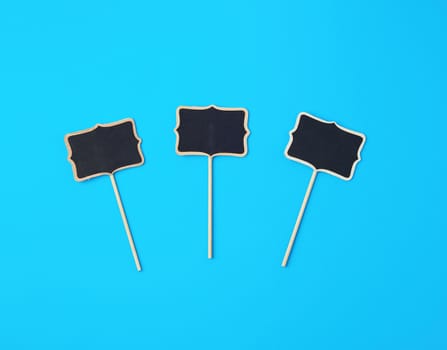 wooden pointer on a stick for writing text, blue background, close up
