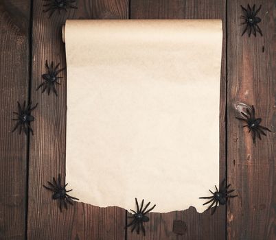 roll of untwisted brown paper on a wooden background, empty place for writing and an invitation to the holiday Halloween