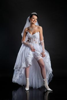 Young beautiful woman in a wedding dress on a studio background
