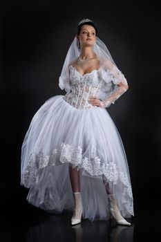 Young beautiful woman in a wedding dress on a studio background