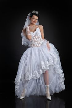 Young beautiful woman in a wedding dress on a studio background