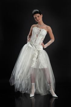 Young beautiful woman in a wedding dress on a studio background