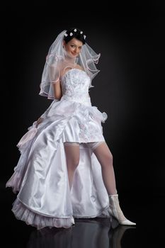 Young beautiful woman in a wedding dress on a studio background