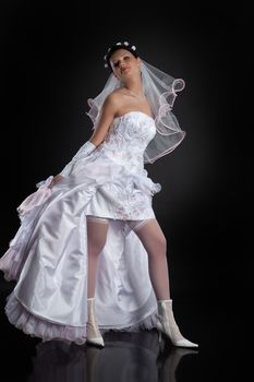 Young beautiful woman in a wedding dress on a studio background