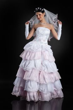 Young beautiful woman in a wedding dress on a studio background