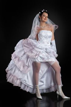 Young beautiful woman in a wedding dress on a studio background