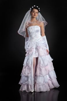 Young beautiful woman in a wedding dress on a studio background