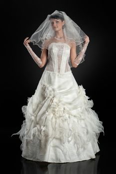 Young beautiful woman in a wedding dress on a studio background
