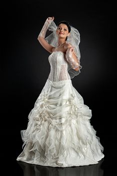 Young beautiful woman in a wedding dress on a studio background
