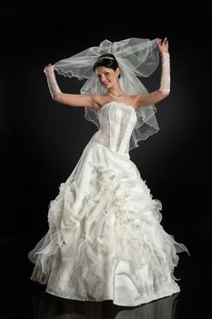 Young beautiful woman in a wedding dress on a studio background