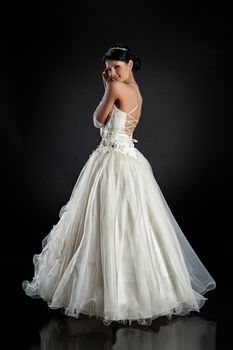 Young beautiful woman in a wedding dress on a studio background