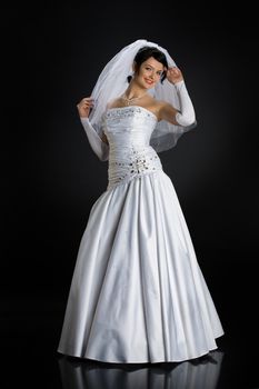 Young beautiful woman in a wedding dress on a studio background