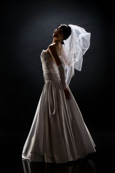 Young beautiful woman in a wedding dress on a studio background