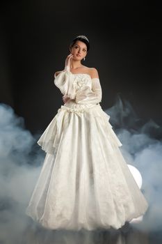 Young beautiful woman in a wedding dress on a studio background