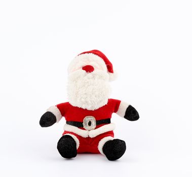 traditional toy santa claus in a red suit and white beard sits on a white background, copy space