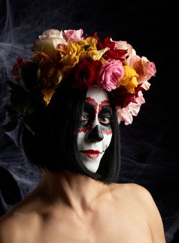 girl with traditional mexican death mask. Calavera Catrina. Sugar skull makeup. girl dressed in a wreath of roses on a background of white web