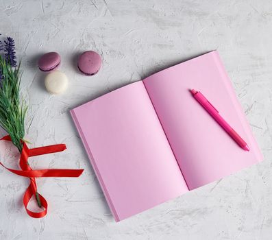 open notebook with blank pink pages, red pencil and a bouquet of lavenders on a white background, top view, flat lay