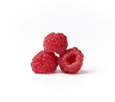 whole ripe red raspberries on a white background, summer berry