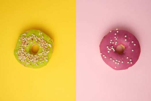 round different donuts with sprinkles on a bright multi-colored background, top view