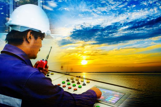 Double Exposure of engineer working in control room and beautiful blue sky with sunset over the sea