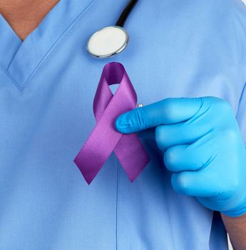 doctor in blue uniform and latex gloves holds a purple ribbon as a symbol of early research and disease control, Alzheimer's disease, cystic fibrosis, lupus, pancreatic cancer, sarcoidosis