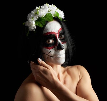 Young beautiful girl with traditional mexican death mask. Calavera Catrina. Sugar skull makeup. girl dressed in a wreath of white roses 