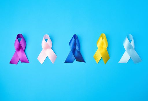 blue, purple, yellow, blue, pink ribbon in the form of a bow, international symbols of diseases on a blue background